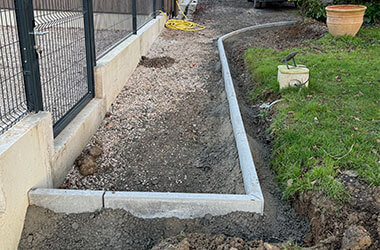 Accueil Bordures béton installées pour créer un cheminement autour d'une maison.